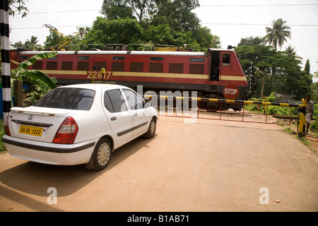 Ein Auto wartet an einem Bahnübergang in der Nähe von Alappuzha Beach in Kerala Indien. Stockfoto