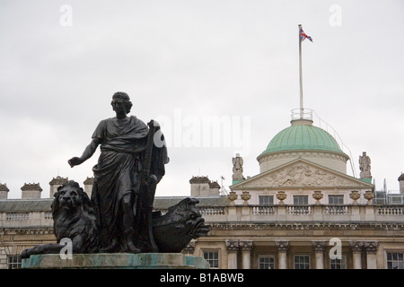 Es steht eine Statue im Hof des Somerset House in London. Eine Flagge weht von der Kuppel des klassischen Gebäudes. Stockfoto