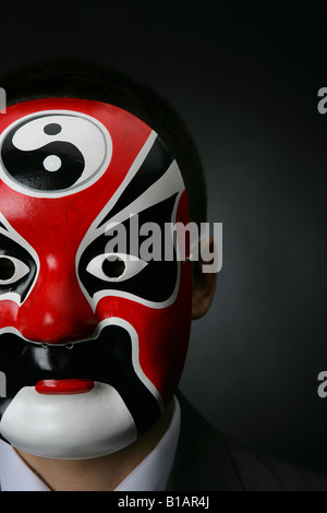 Chinesischer Unternehmer trägt eine chinesische Oper Maske Stockfoto