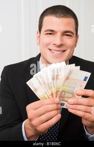 Junger Mann hält Euro-Banknoten, Porträt Stockfoto