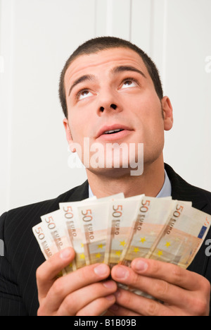 Junger Mann hält Euro-Banknoten, Porträt Stockfoto