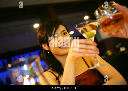 junge Frau Toasten in bar des Hotels Stockfoto