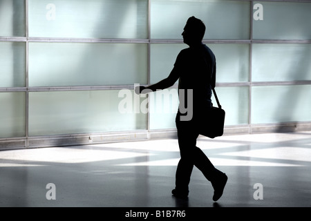 Silhouette eines Mannes zu Fuß mit einer Tasche Stockfoto