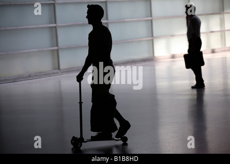 Silhouette eines Mannes auf einem Roller Stockfoto