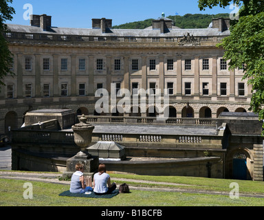 Zwei Frauen Essen Picknick Mittagessen mit Blick auf The Crescent & Pump Room, The Pisten, Buxton, Peak District in Derbyshire, England Stockfoto