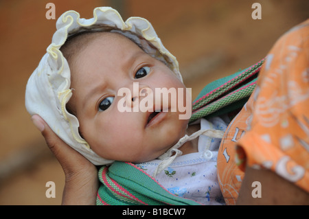 Gesicht eines vietnamesischen Baby-Mädchens, das in einer Schlinge Central Highlands Vietnam getragen wird Stockfoto