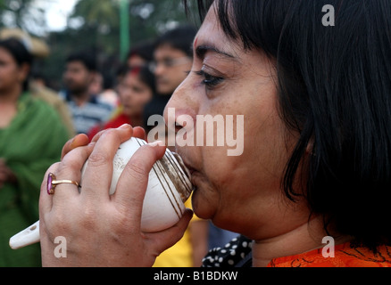 Eine bengalische Frau bläst eine Muschelschale als eine Form des Gottesdienstes feiern das Eintauchen eines Durga Idol für Dasara, Indien Stockfoto