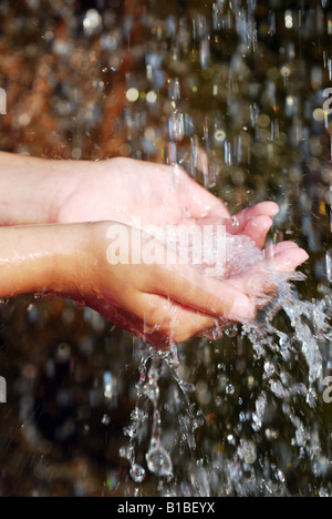 Kinder fangen fallenden Wassers mit ihren Händen Umweltkonzept Stockfoto