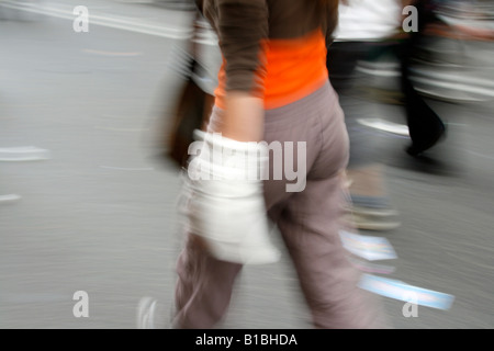 junge Frau mit Bandage am Armverletzung in Stadt Stockfoto