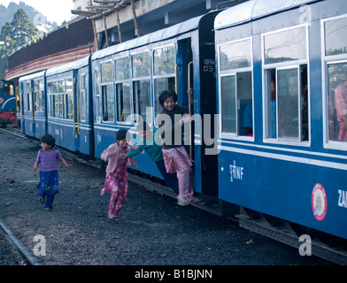 Kinder springen auf dem Darjeeling-Spielzeug trainieren, da er die Station verlässt Stockfoto
