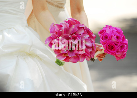 Braut und Brautjungfer mit rosa Blumen-bouquets Stockfoto