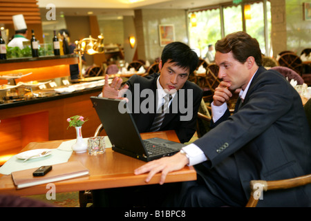 Unternehmer und Unternehmerin im Hotelrestaurant im Gespräch Stockfoto