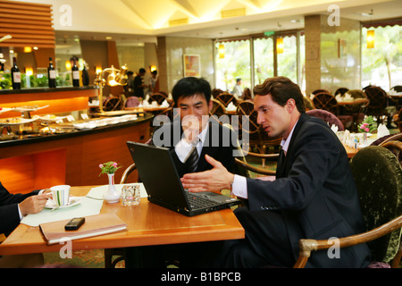 Unternehmer und Unternehmerin im Hotelrestaurant im Gespräch Stockfoto