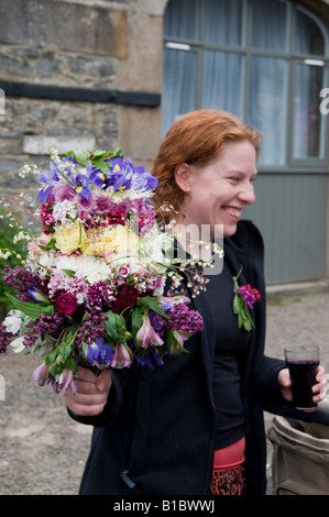 Rote behaarte Frau mit Bouquet von Blumen gepflückt Festival in Castleton Derbyshire in den Peak District England Stockfoto