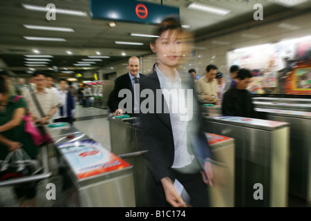 viele Menschen aus verschiedenen Kulturen, die zu Fuß über das Drehkreuz von Subway, Shanghai, China Stockfoto