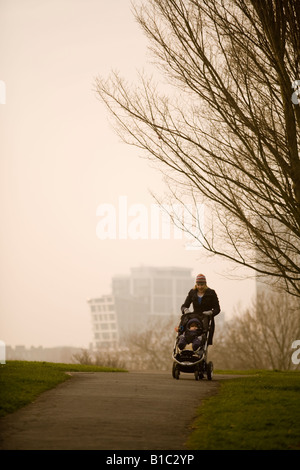 Frau, die ein Kind im Buggy schieben, auf Primrose Hill, London Stockfoto
