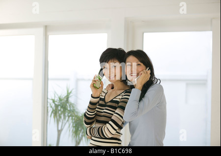 Zwei Frauen, die Benutzung von Mobiltelefonen Stockfoto
