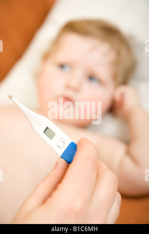 Arzt mit Baby und Lesung Thermometer messen Fokuspunkt im Maßstab Stockfoto