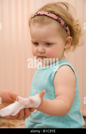 Arzt Kinderarzt, einen Verband auf ein kleines Mädchen-arm Stockfoto