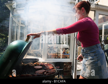 Vereinigtes Königreich-Frau auf einem Grill kochen Stockfoto