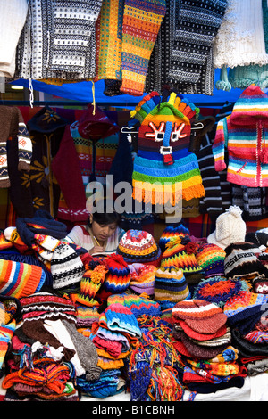 Mädchen machen ihre Hausaufgaben während der Arbeit an einem Marktstand in Otavalo im Norden Ecuadors in Südamerika Stockfoto