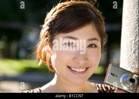 Junge Frau Holding Digitalkamera Stockfoto