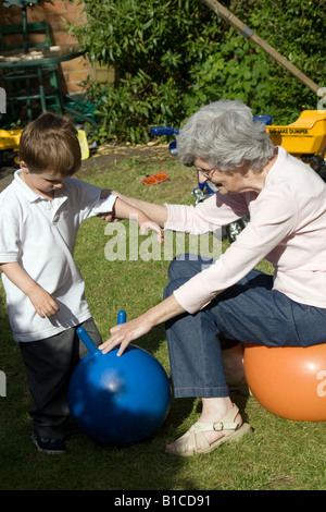 Großmutter und Enkel spielen auf Platz Trichter in einem Garten hinter dem Haus Stockfoto