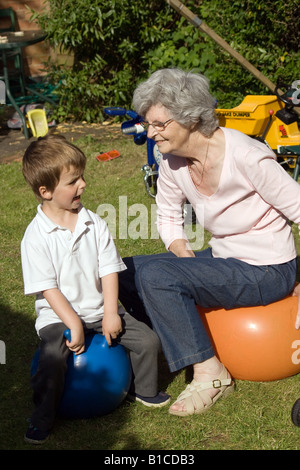 Großmutter und Enkel spielen auf Platz Trichter in einem Garten hinter dem Haus Stockfoto