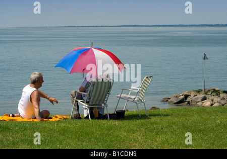 Zwei Personen saßen auf einem Grünstreifen mit Blick auf The Solent Taken in Lee On The Solent Beach-Sommer 2008 Stockfoto