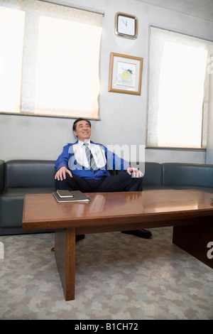 Reifer Mann im Sofa sitzen Stockfoto