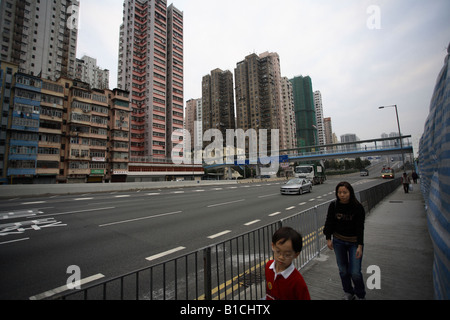 Mutter und Kind zu Fuß entlang der Straße Ferry Street im Stadtteil Kowloon, Hong Kong, China Stockfoto