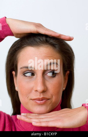 Porträt einer jungen Frau, hand rollt ihre Augen und ein Betrieb über den Kopf und unter dem Kinn Stockfoto