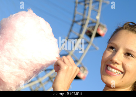 glückliche junge Frau mit Zuckerwatte vor der Riesenrad Wiener Prater, Österreich, Wien Stockfoto