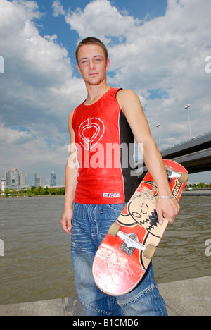 männliche Teenager mit Skateboard auf der Donauinsel Stockfoto