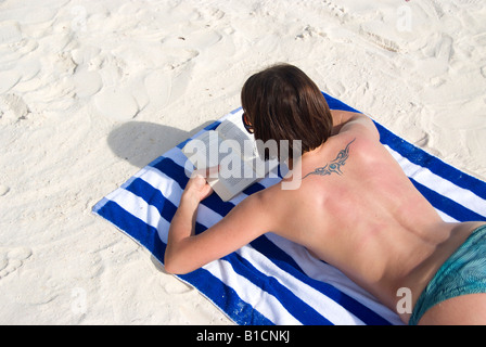 Frau am Strand liegend ein Buch lesen, Philippinen Stockfoto