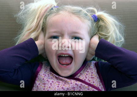 schreiende Mädchen hält Ohren geschlossen Stockfoto