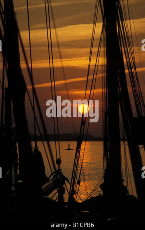 Sonnenuntergang über Elbe, gesehen durch Masten und Rigg von historischen Segelschiff in Hamburg, Deutschland Stockfoto