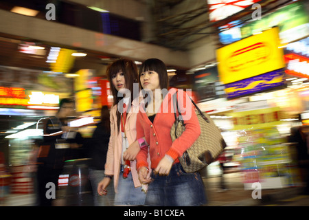 Mädchen im Teenageralter an einer Einkaufsstraße im Stadtteil Kowloon, Hong Kong, China Stockfoto