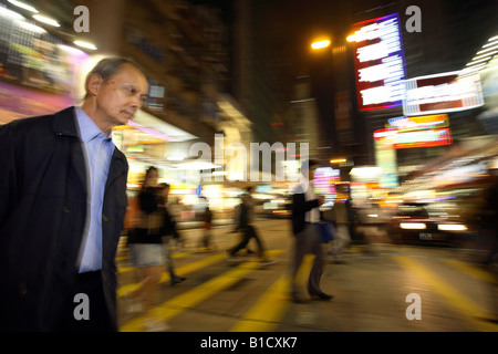 Menschen überqueren einer Straße im Stadtteil Kowloon, Hong Kong, China Stockfoto