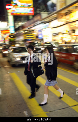 Jugendlichen Studenten überqueren einer Straße im Stadtteil Kowloon, Hong Kong, China Stockfoto