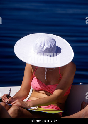 Frau schreibt einen Brief auf einem Boot Stockfoto
