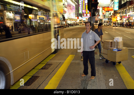 Man wartet auf einer Straße im Stadtteil Kowloon, Hong Kong, China Stockfoto