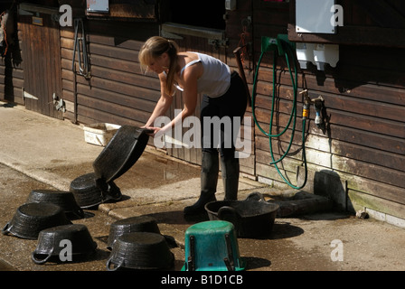 Frau Wasch- und Reinigungsmitteln Pferd Futter Schalen und Kautschuk-Eimer Stockfoto