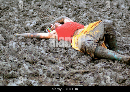 Ein Festival-Goer liegt wieder im Schlamm beim Glastonbury Festival 2007. Stockfoto