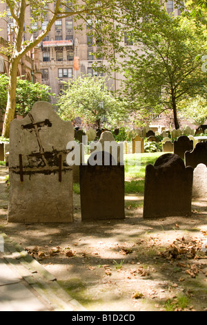 Alte Grabsteine auf dem Kirchhof der Trinity Church, New York City – die historische anglikanische Gemeinde, die 1697 gegründet wurde und mit Grabsteinen aus der frühen Kolonialzeit versehen ist. Stockfoto