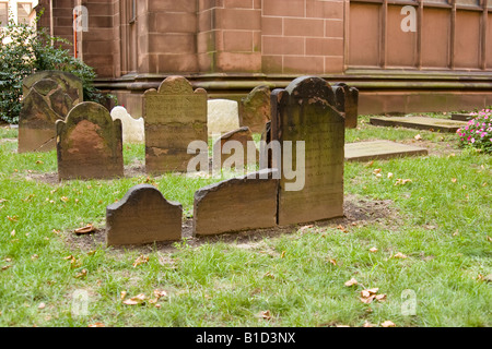Alte Grabsteine auf dem Kirchhof der Trinity Church, New York City – die historische anglikanische Gemeinde, die 1697 gegründet wurde und mit Grabsteinen aus der frühen Kolonialzeit versehen ist. Stockfoto