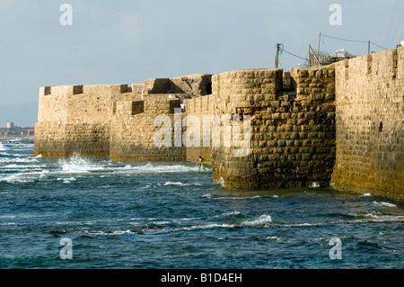 Fischer seine Netze zu sammeln, wie die Sonne am Fuße des die Zinnen des alten Kreuzfahrer Stadt Akko (Akko), Israel Stockfoto