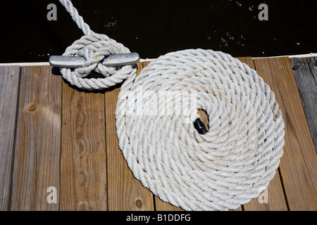 Segeln Linien zusammengerollt fein säuberlich auf Dock neben Klampe Stockfoto