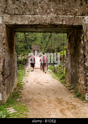 Wanderer, die über eine Brücke auf dem Singalila Ridge Trek entlang der Grenze Nepal Indien Stockfoto