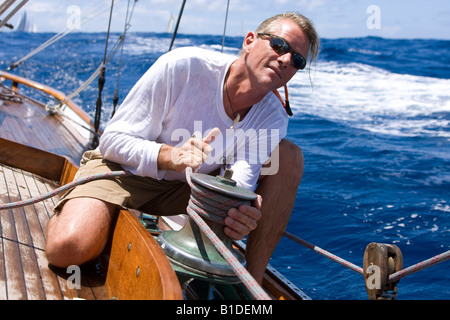 Ein Besatzungsmitglied trimmt den Kopf Segel an Bord Segeln Jolle SY Galatea in Antigua während der 2008 Antigua Classic Yacht Regatta Stockfoto